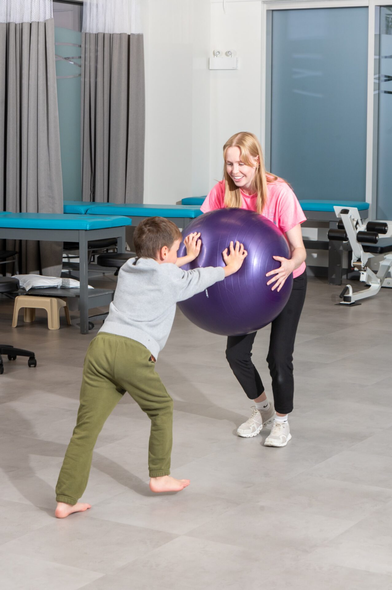 young boy and physio work on strengthening with exercise ball to treat Muscular Dystrophy